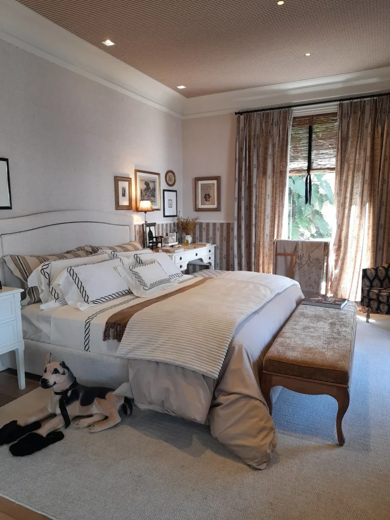 Bedroom with layered lighting including bedside lamp ambient ceiling lighting and soft natural light