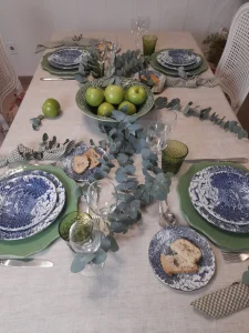 Overhead view of a balanced table composition with silver flatware and botanical accents