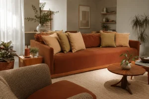 Terracotta upholstered sofa with layered linen cushions in an elegant living room