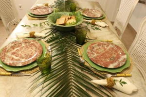 Elegant-layered-table-with-decorative-dinner-plates-green-chargers-woven-placemats-and-botanical-centerpiece