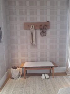 Minimal-bedroom-corner-with-a-wooden-bench-and-simple-wall-hooks