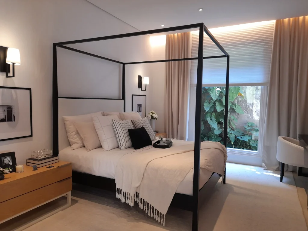 Modern-canopy-bed-in-a-neutral-bedroom-with-clean-lines-soft-bedding-and-natural-light.