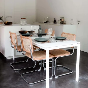 Small dining room with slim dining chairs creating an open and airy feeling